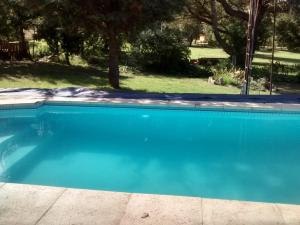 a large blue swimming pool in a yard at Siete Colores, pileclimatiz in Villa Ventana
