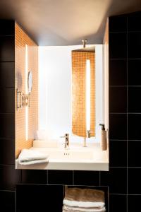 ein Bad mit einem Waschbecken und einem Spiegel in der Unterkunft Hotel Zum Verwalter Dornbirn in Dornbirn