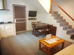 a kitchen and dining room with a table and a staircase at Hibiscus Cottage in Ban Dan Kao