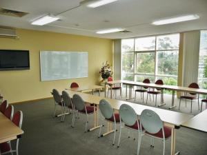 a conference room with tables and chairs and a screen at Parramatta City Motel in Sydney