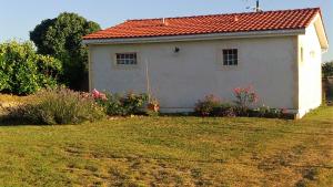 una pequeña casa blanca con techo rojo en Le Soleil en Gironde, en Vrillant