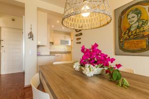 une table à manger avec des fleurs roses et un lustre dans l'établissement CHIQUITA PLACE, Praia da Luz, à Luz 37 autres photos