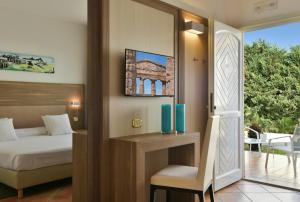 a living room with a large window and a painting on the wall at Paestum Inn Beach Resort in Paestum