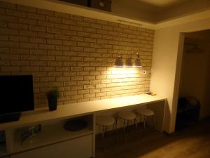 a room with a bar with stools in front of a brick wall at Mountain View Studio Apartment in Poprad