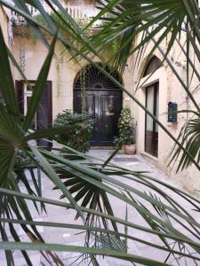 uma porta da frente de uma casa com uma palmeira em Dimora "I Santi Patroni" em Lecce