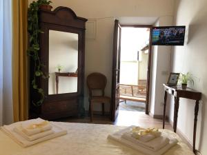 a bedroom with two towels on a bed with a mirror at Relais Puccini in Lucca