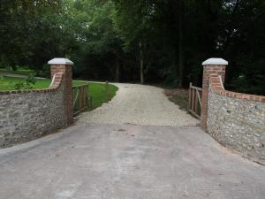 a bridge over a road with a stone wall at West Cottage, Cerne Abbas Lane in Dorchester