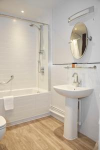 uma casa de banho com um lavatório, um chuveiro e um WC. em White Hart Hotel by Greene King Inns em Coggeshall