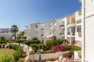 un immeuble d'appartements avec des fleurs et des plantes dans l'établissement CHIQUITA PLACE, Praia da Luz, à Luz