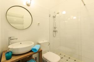 a bathroom with a sink and a toilet and a mirror at Rental Apartments Wilcza in Warsaw +11 photos