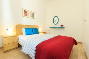 a bedroom with a bed with a red and blue blanket at Rental Apartments Wilcza in Warsaw