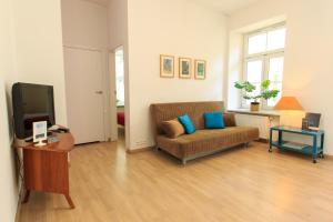 a living room with a couch and a tv at Rental Apartments Wilcza in Warsaw
