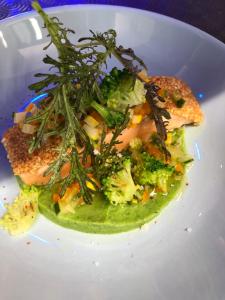 a white plate of food with broccoli and fish at Hotel-Restaurant Lann Roz / Côte Cuisine in Carnac