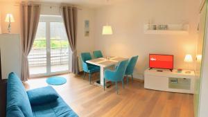 a living room with a table and chairs and a television at Fewo Mittelmole in Warnemünde