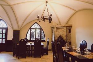ein Esszimmer mit Tisch und Kamin in der Unterkunft Vila Alsace Podu' cu Lanturi in Bacău