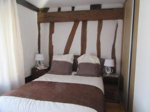 a bedroom with a wooden bed with two lamps at Appartement au bord de l'Eure in Léry