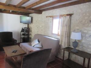 a living room with a couch and a table and a window at Appartement au bord de l'Eure in Léry