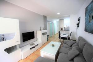 een woonkamer met een bank en een tv bij Fantastic apartment near the beach in Playa del Inglés