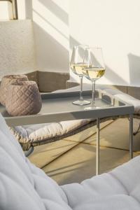 the coolest loft and terrace-varkiza sea view في فاركيزا: طاولة مع كأسين من النبيذ عليها