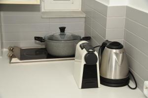 a kitchen counter with a coffee pot and a toaster at the coolest loft and terrace-varkiza sea view in Varkiza