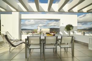 a dining room with a table and chairs on a balcony at the coolest loft and terrace-varkiza sea view in Varkiza