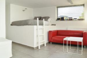 a bedroom with a bunk bed and a red couch at the coolest loft and terrace-varkiza sea view in Varkiza