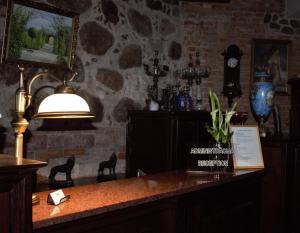 a room with a table with a lamp and a stone wall at Vecgulbenes muiža in Gulbene