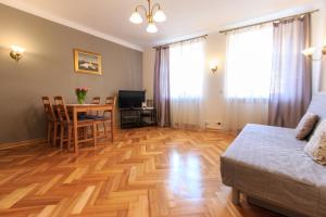 a living room with a table and a bed and a dining room at Rental Apartments Szeroki Dunaj in Warsaw