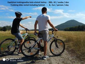 two men standing with their bikes on a dirt road at Trapani glamping camp in Růžová
