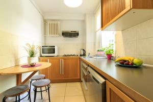 a kitchen with wooden cabinets and a table with a bowl of fruit at Rental Apartments Warecka in Warsaw