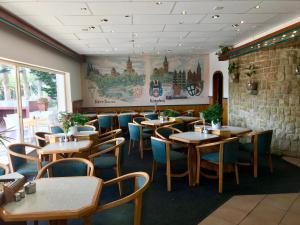 a restaurant with wooden tables and blue chairs at Hotel Schweizerhaus/Cafe Anton in Swakopmund