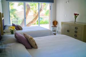 a bedroom with two beds and a large window at 3BR Home, Steps from Spectacular Beach, Private Pool in Playa del Carmen