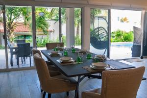a dining room with a table and chairs and a table and chairsktop at 3BR Home, Steps from Spectacular Beach, Private Pool in Playa del Carmen