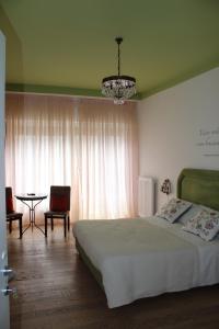 1 dormitorio con cama, mesa y lámpara de araña en La Dimora del Conte, en Pescara