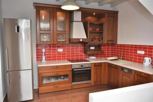 a kitchen with wooden cabinets and a stainless steel refrigerator at Country Villas in Stelida