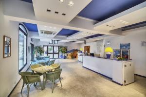 a lobby with blue ceilings and a table and chairs at Résidence Pierre & Vacances L’Anse De Pramousquier in Le Lavandou