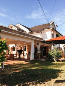 ein weißes Haus mit einer Terrasse und einem Hof in der Unterkunft Sura Inn in Dungun