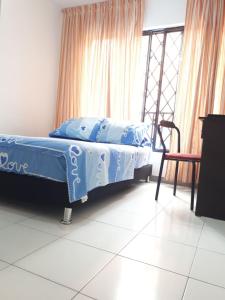 カリにあるHOSPEDAJE VALLE DEL LILIのベッドと椅子と窓のある寝室