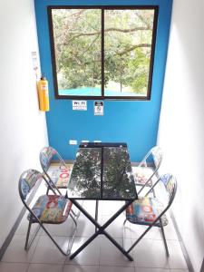 カリにあるHOSPEDAJE VALLE DEL LILIの窓のある部屋(テーブルと椅子2脚付)