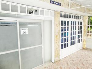 カリにあるHOSPEDAJE VALLE DEL LILIの看板付きガレージドア +4枚の写真