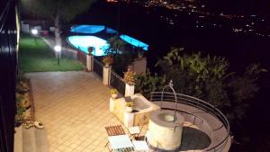 a view of a patio at night with a swimming pool at Bellavista Etna in Mascali