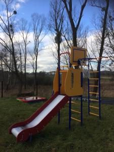 a playground with a slide in the grass at Apartament Fibra Cappuccino in Rybnik