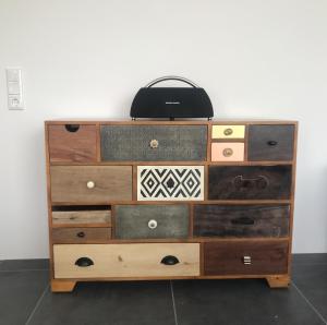 a dresser with four drawers and a black bag on top at The Penthouse in Kaiserslautern