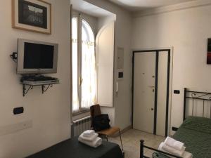 ローマにあるCasa vacanze Little Queenのベッドルーム(ベッド1台、テレビ、椅子付)