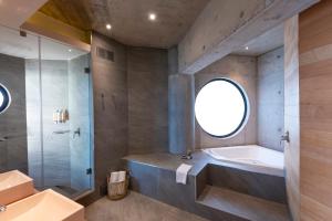 a bathroom with a tub and a shower and a sink at Hotel AWA in Puerto Varas