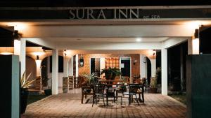 a restaurant with a table and chairs on a patio at Sura Inn in Dungun