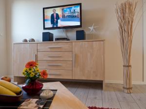 a living room with a tv on top of a dresser at Appartement Strandstraße 10, Büsum in Büsum