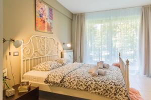 een slaapkamer met een bed met twee teddyberen erop bij One Love Metropolitan Gardens Studio in Boekarest