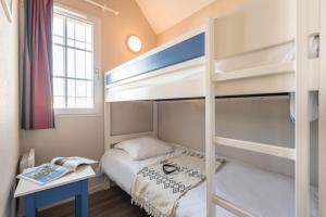 niewielka sypialnia z łóżkiem piętrowym i biurkiem w obiekcie Résidence Pierre & Vacances Cap Marine w mieście Guilvinec
