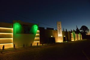 a building with green lights on the side of it at Villages Motel by Drops in Lages
